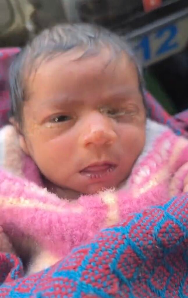 ठंड में गड्ढे से बचाई गई नवजात बच्ची को गोद में लेकर जाता पुलिसकर्मी